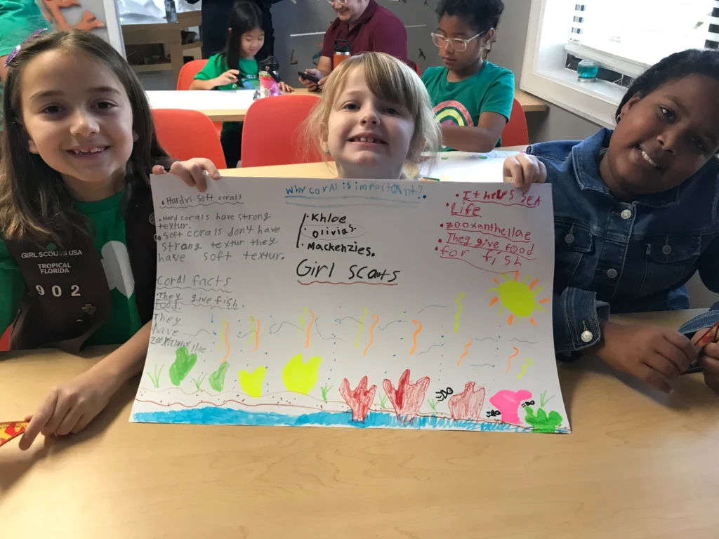 Girl scouts displaying coral drawing