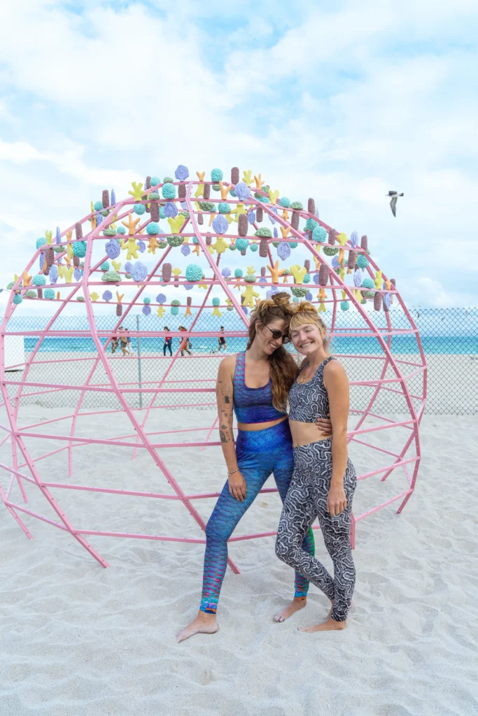 The artists proudly posing in front of their sculpture on Miami Beach. Photo courtesy of Waterlust.