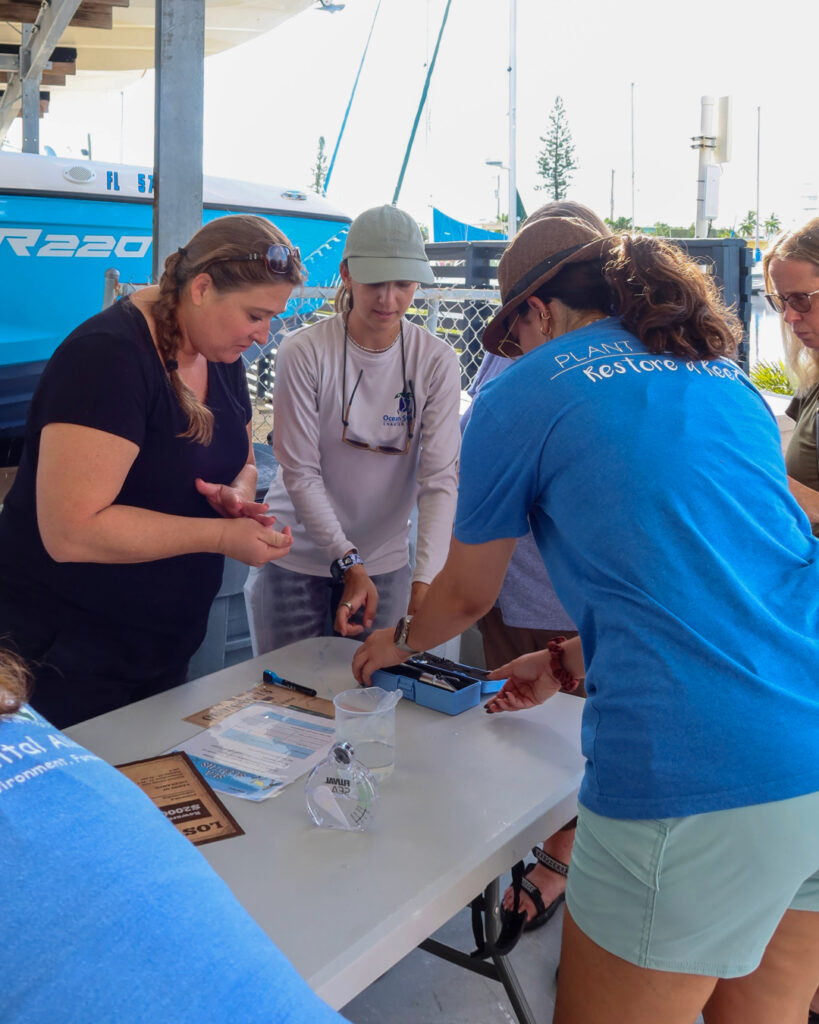 A small group of teachers gathers around a table outdoors, testing water samples as part of CRF’s hands-on water quality lab during the educator retreat.